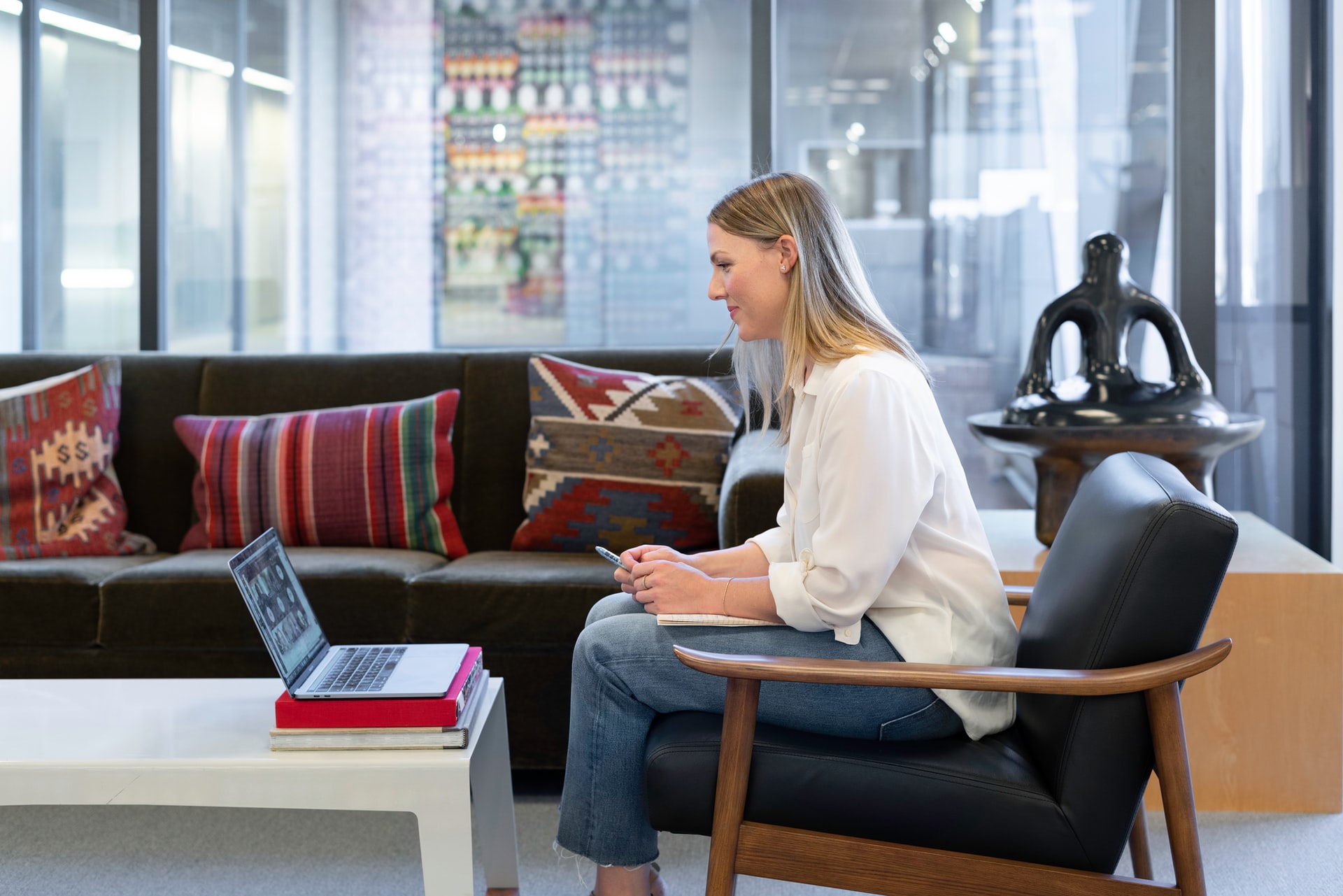Person sitzt mit MacBook auf einem Sessel